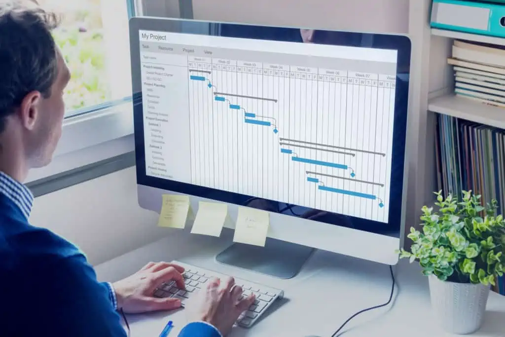 Mitarbeiter bearbeitet Gantt-Diagramm an PC-Arbeitsplatz zur Berechnung der Durchlaufzeit