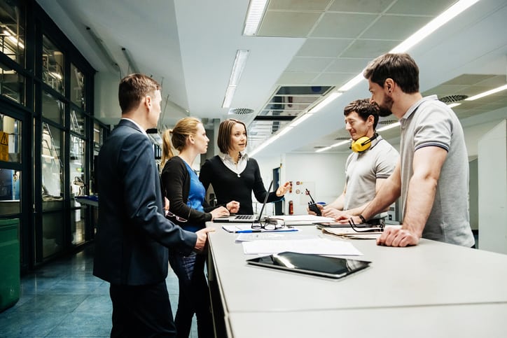 A team of engineers holding a meeting in a factory MIt BIM wird auch der Betireb der Gabäude digital unterstützt. Ideen in der Fertigungsplanung können z. B. anhand digitaler Bauwerksmodelle erörtert werden.