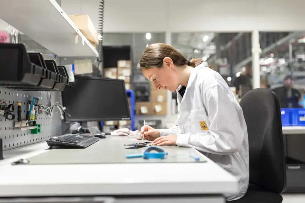 Employee at repair station for smartphones in a production facility