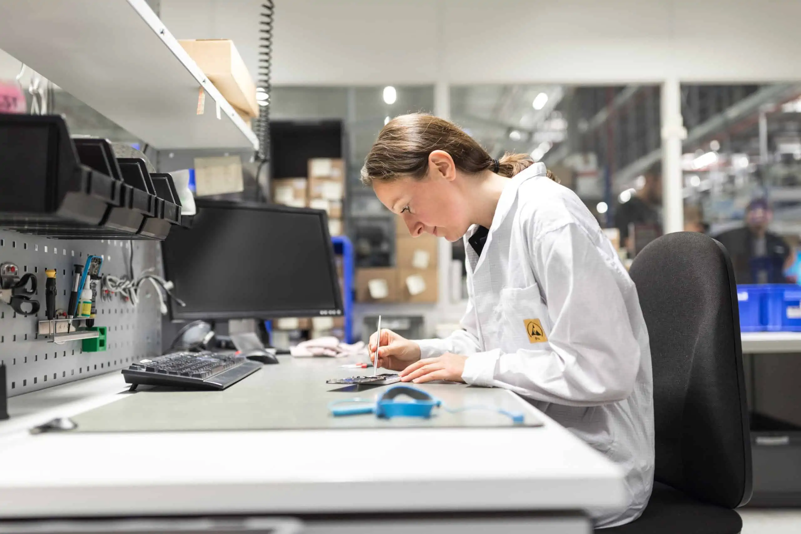 Employee at repair station for smartphones in a production facility