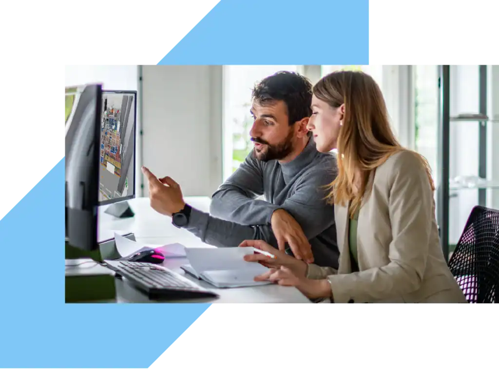 a man and a woman looking at a 3d layout on a monitor