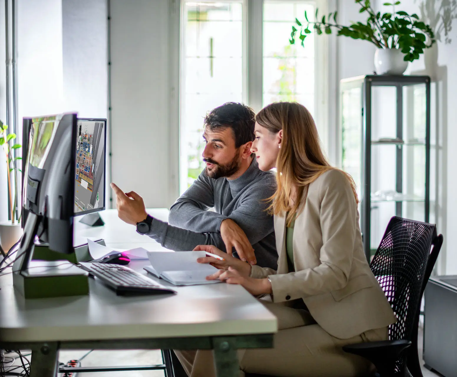 A man and a woman sit at a desk and discuss visTable layouts