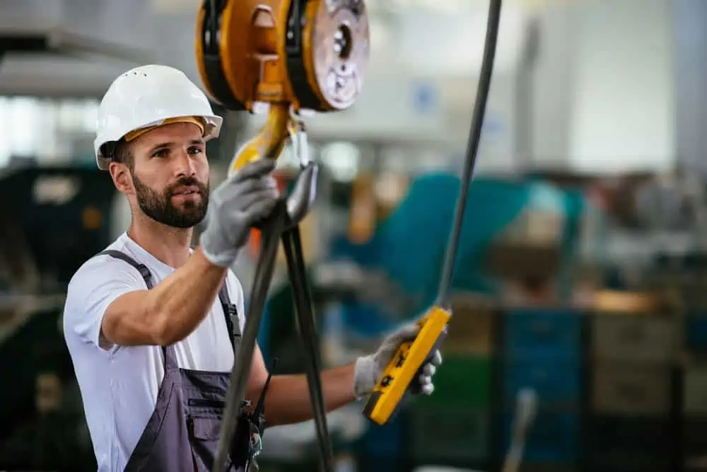 worker and operator of overhead shop crane in a factory